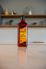 Bottle of Nutrolein Red Palm Oil on a reflective surface with a blurred background